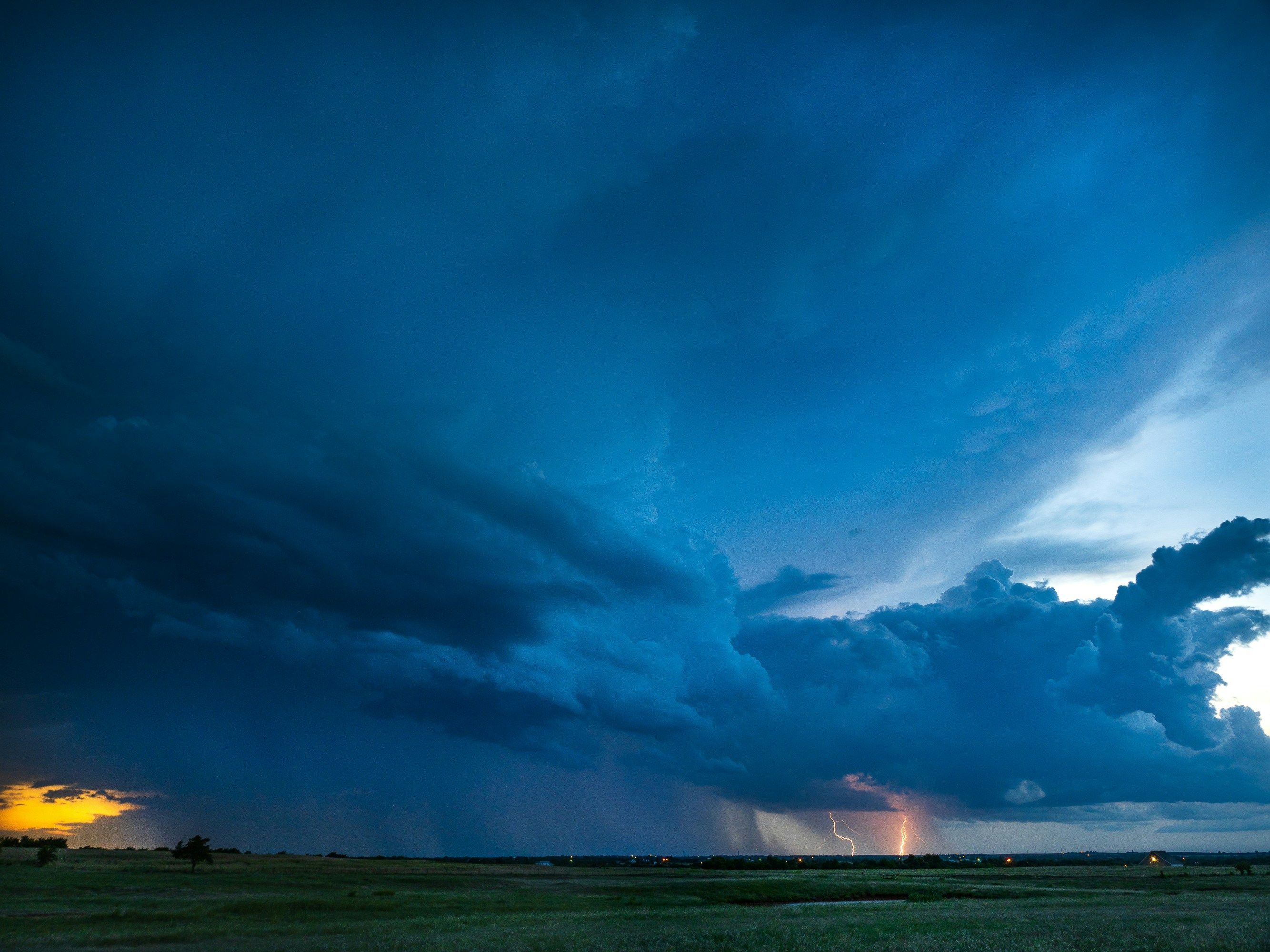 Blue hour storm with clearing skies, lightning, and rain shafts showing dramatic post-storm magic hour conditions